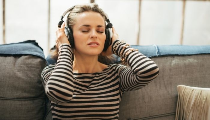 women listening to something wearing headphone