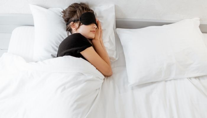 woman sleeping covering her eyes 