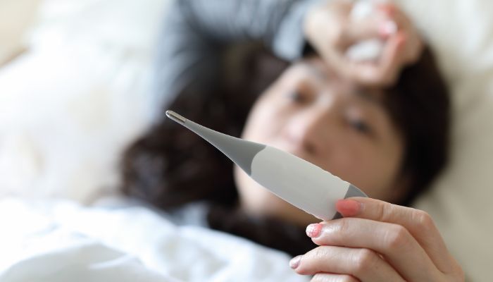 women lying in bed checking a rapid tester