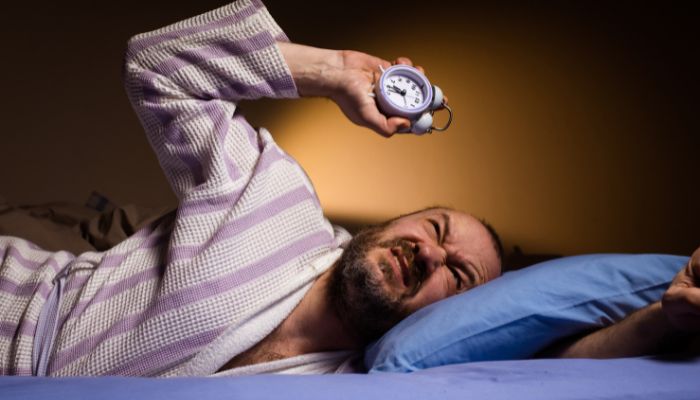 guy holding clock upset 
shift work disorder