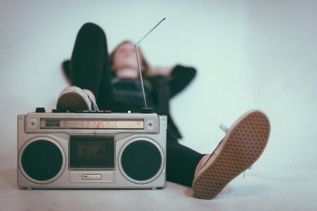 woman laying on bed near gray radio
using music and sound
