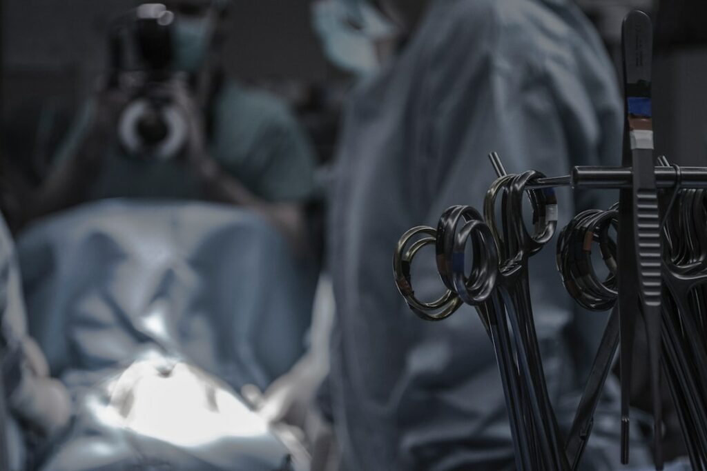 gray surgical scissors near doctors in operating room
