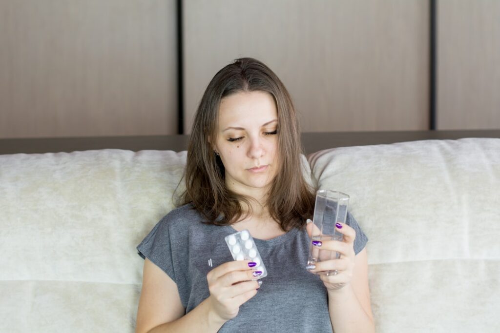 woman taking medicine and drinking water
sore throat at night