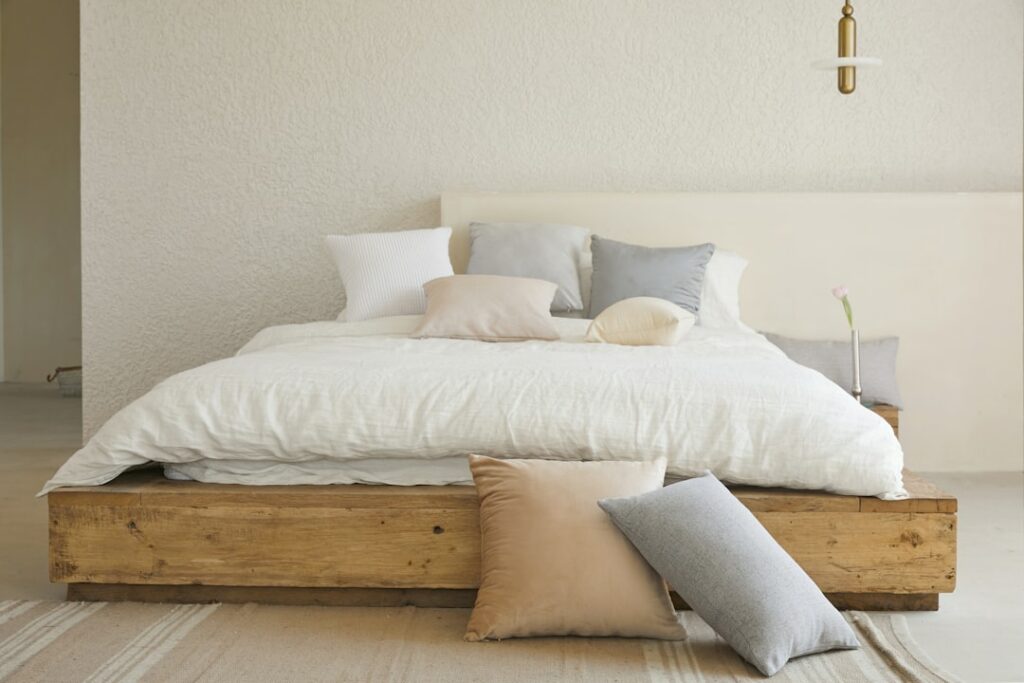 white bed pillow on brown wooden bed frame
sleeping with head facing south