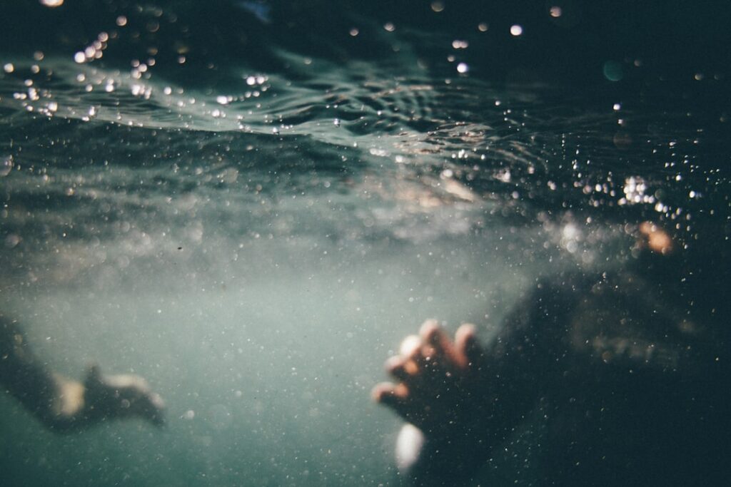 person body and hand under water