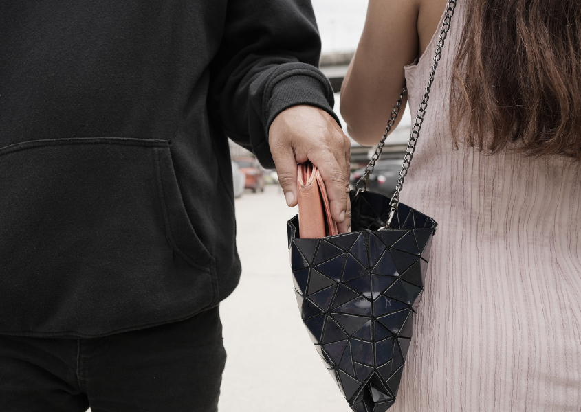 man taking female wallet out of bag