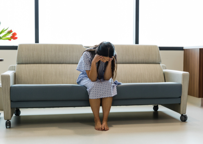 woman sitting on couch and upset over loss 